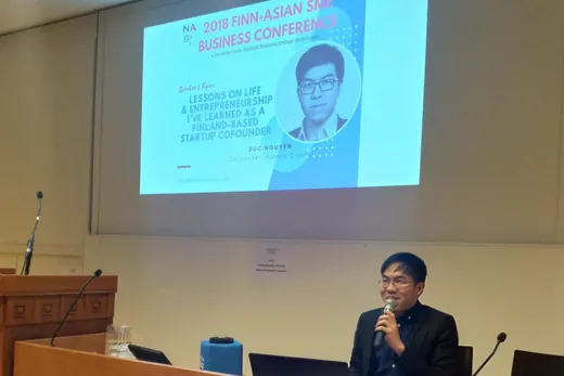 Daniel seated at a lectern with a microphone, the slide reading 2018 Finn-Asian SME Business Conference