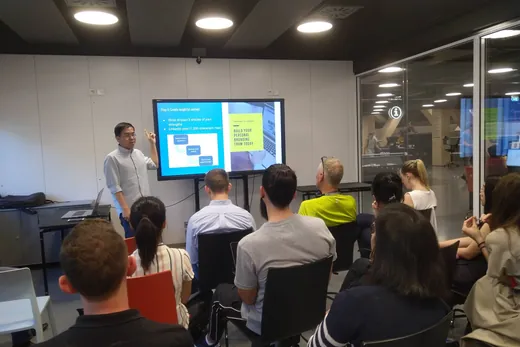 Daniel pointing at a screen while a seated group follows along